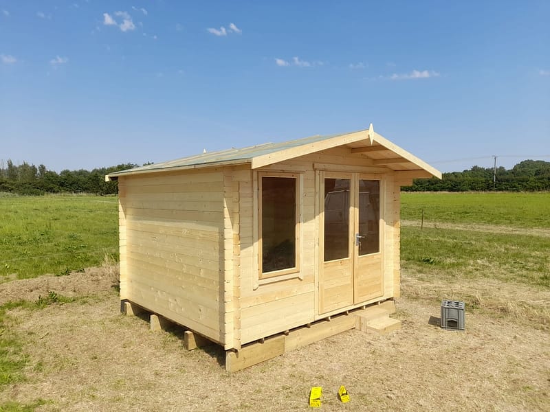 newly built wood cabin in field